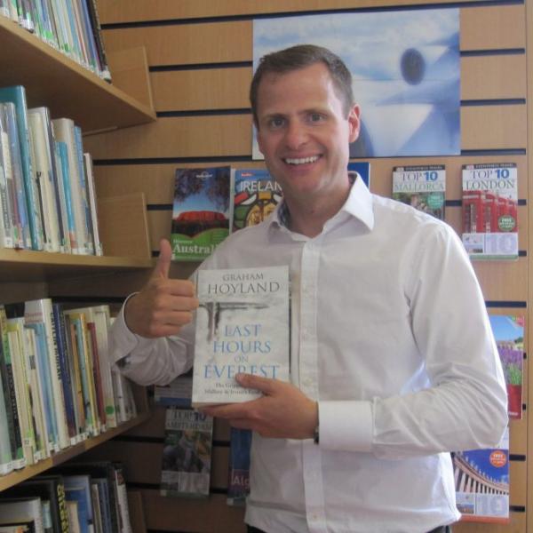 John Burke holding a copy of his book