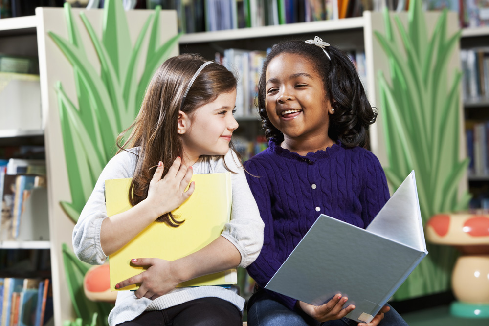 Two girls enjoying books