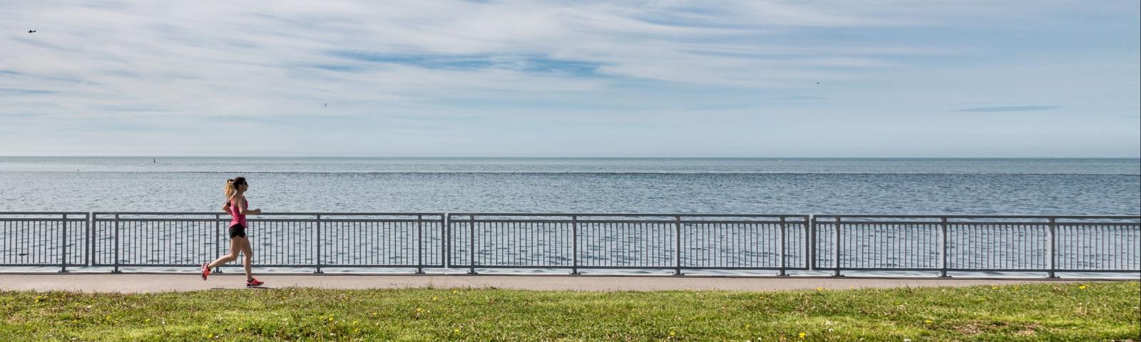 Image of a woman running by the coast