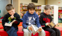 Three boys on a couch reading
