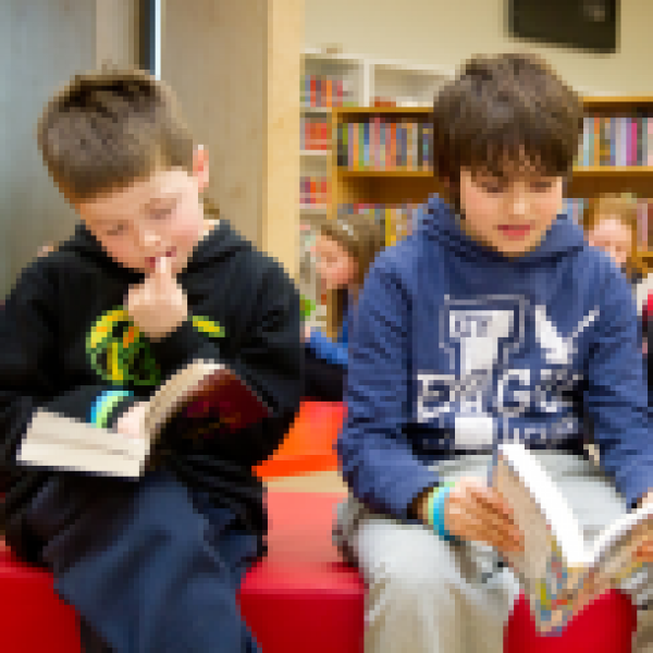 Three boys on a couch reading