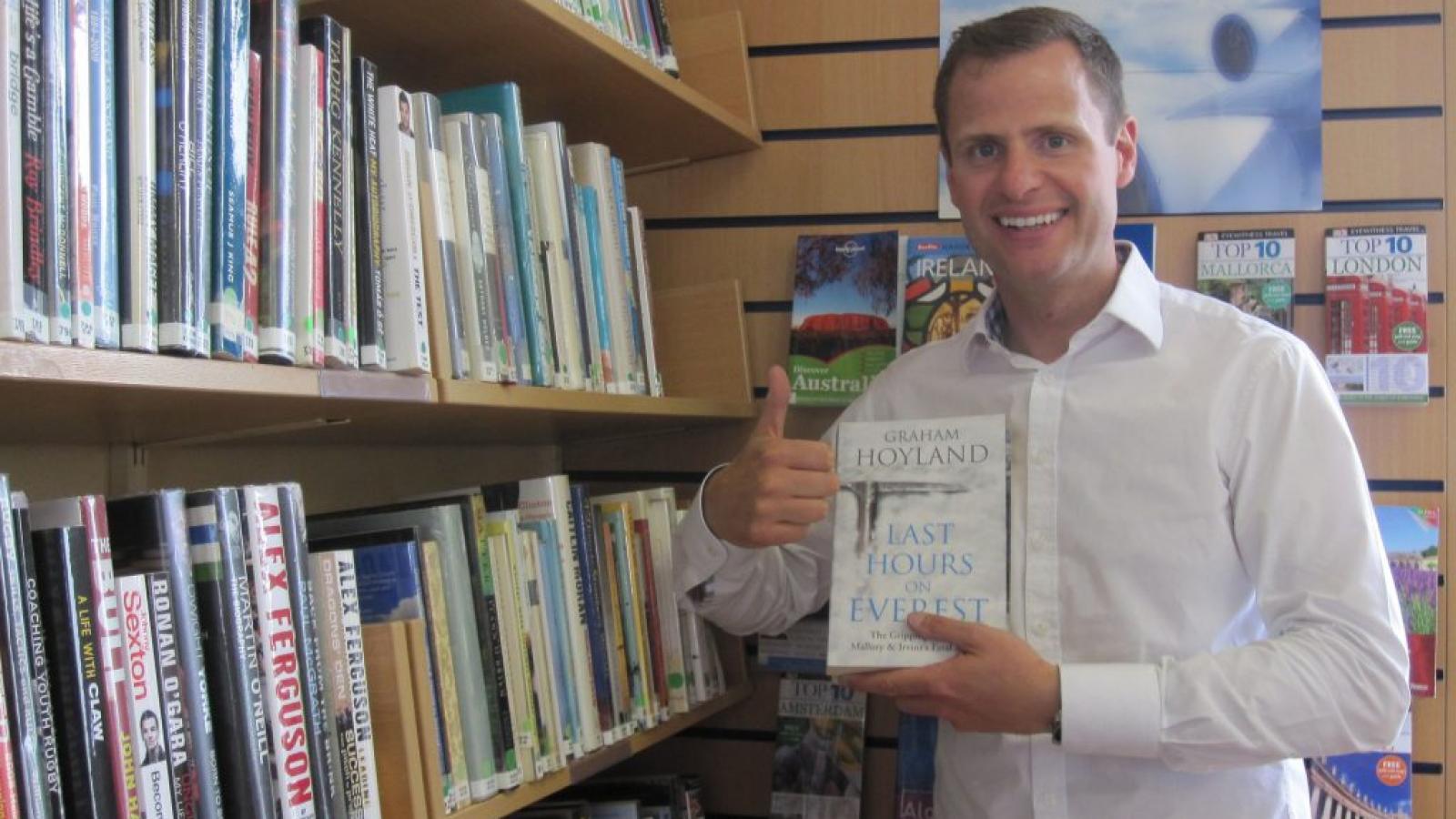 John Burke holding a copy of his book