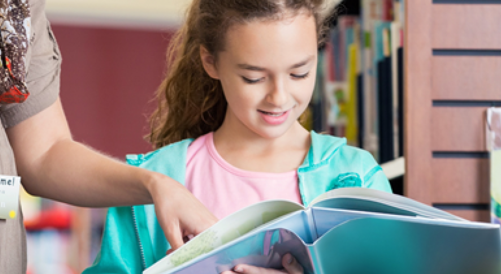 A girl looks at a book in a library