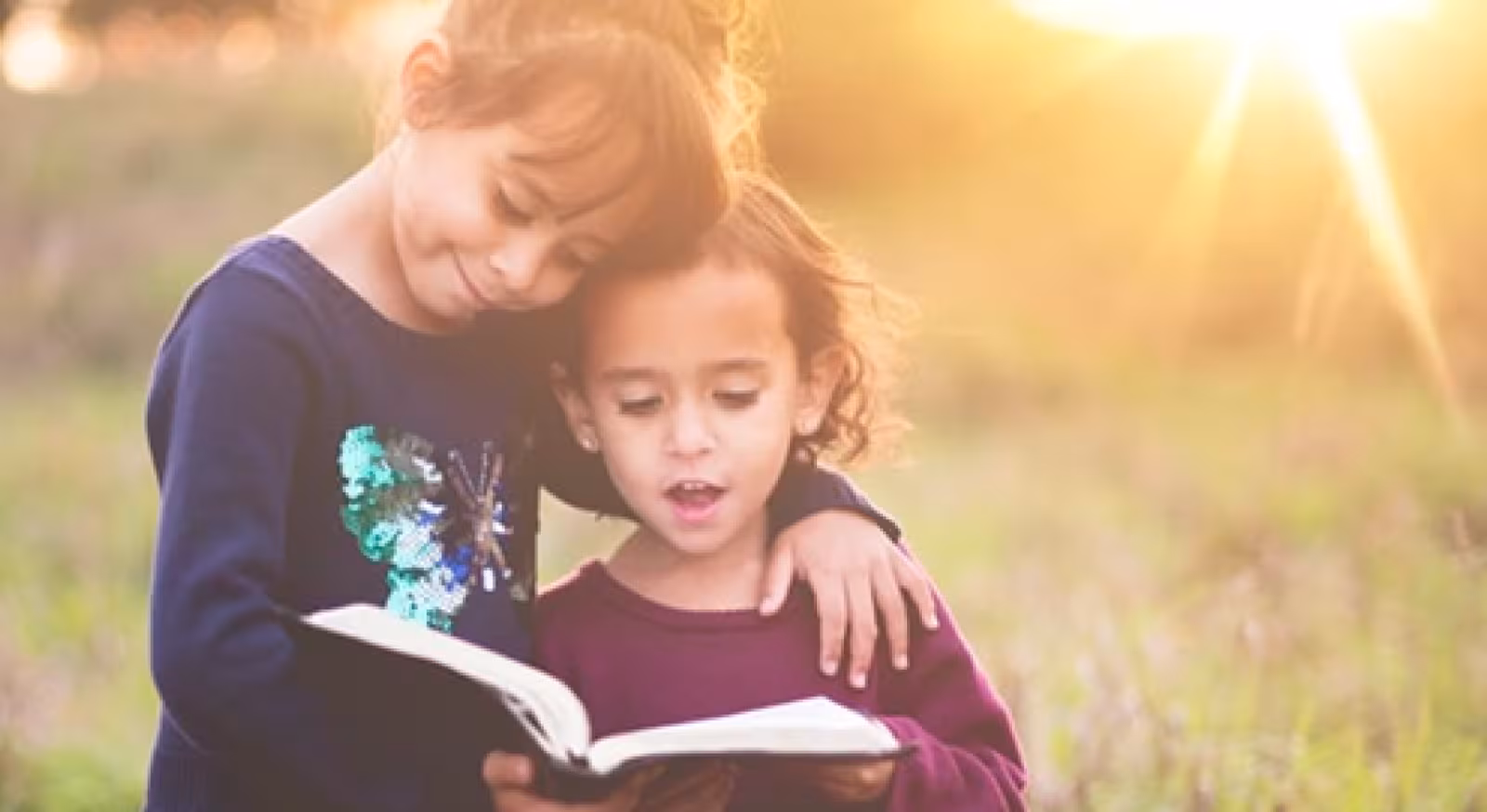 Two girls read a book