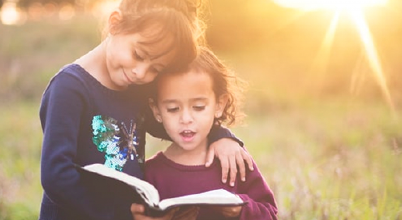 Two girls read a book